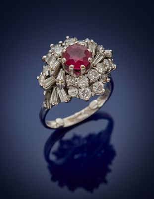 a close up of a diamond and ruby ring on a blue background