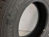 a close up of a tire on a white surface with a hand holding it