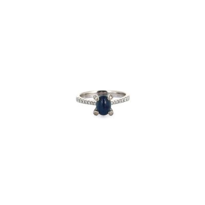 a close up of a diamond and sapphire ring on a white background