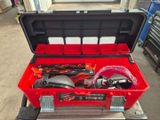 une boîte à outils rouge contenant des outils, dans un garage