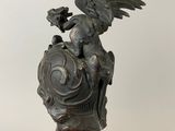 bronze statue of a woman with a bird on her head