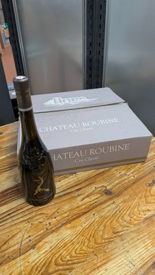 une bouteille de vin posée sur une table à côté d'un carton de vin