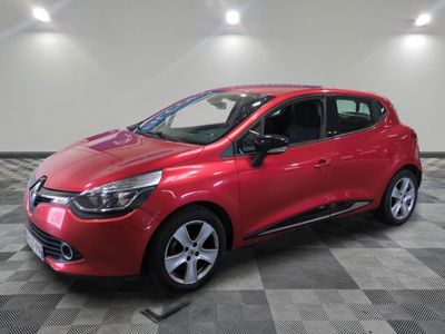 une voiture rouge est garée dans une pièce au sol en damier