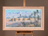 a painting on a easel with a painting of a village in the background