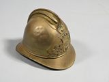 a gold fireman ' s helmet sitting on a white surface