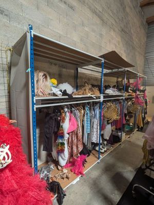 a lot of clothes on the shelves in the room