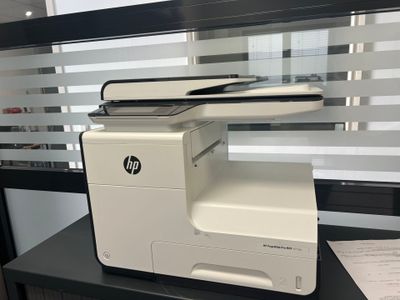 a printer sitting on a desk in front of a window