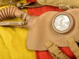 a gas mask on a bed with a yellow and red blanket