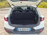 the back of a white car with its trunk open in a parking lot