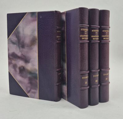 trois livres sont alignés sur une surface blanche