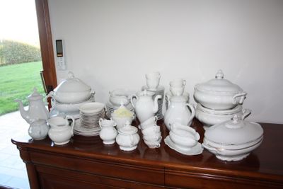 a lot of white dishes and cups on a dresser