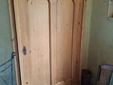 une armoire placée dans un coin de la pièce, avec une chaise devant