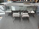 une table de salle à manger en verre avec quatre chaises et une bibliothèque