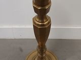 a gold candle holder sitting on the floor in a room