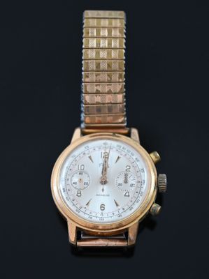 a gold watch with a white face on a black surface