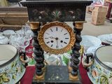 une horloge posée sur une table à côté de deux vases