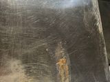 a piece of metal that has been scratched and is sitting on a table