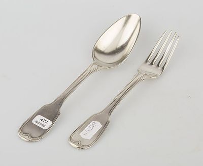 two forks and a spoon on a table with a tag on it