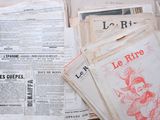 several newspapers are stacked on top of each other on a table
