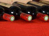 several bottles of wine are lined up on a red cloth