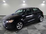 une voiture noire est garée sur le sol en damier d'un garage