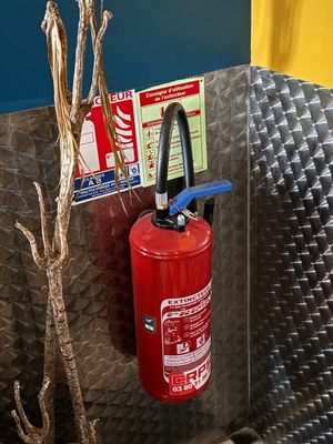 un extincteur fixé au mur