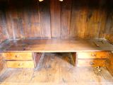 un bureau en bois à deux tiroirs, dans un coin de la pièce