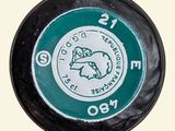 a close up of a black and green button with a horse on it