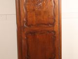 a tall wooden cabinet in the corner of a room