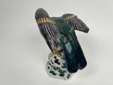 a figurine of a bird that is sitting on a rock