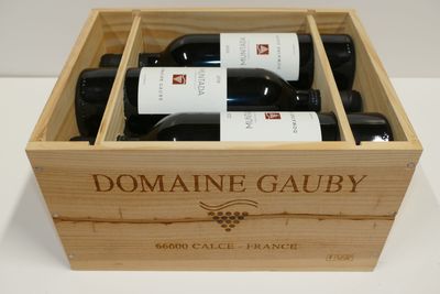 des bouteilles du Domaine Gauby dans un coffret en bois posé sur une table