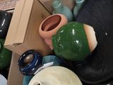 many different colored vases in a box on the floor