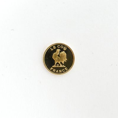 La pièce est en or et représente un coq.
