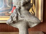 a statue of a woman holding a dog on a table
