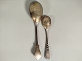 two spoons that are sitting next to each other on a table