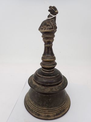une figurine antique en bronze représentant une femme avec un oiseau sur la tête