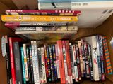plusieurs livres empilés dans une boîte