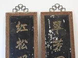 two mirrors with asian writing on them hanging on a wall