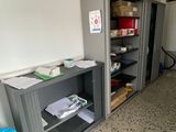 un réfrigérateur dans un coin de la pièce, à côté d'une bibliothèque