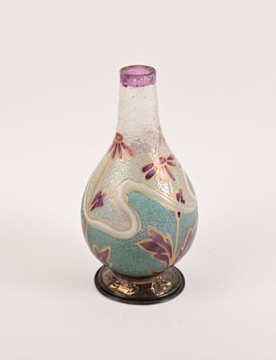 un vase en verre avec un couvercle violet, posé sur un socle