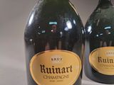 two bottles of champagne sitting next to each other on a table
