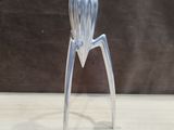 a silver metal sculpture of a person on a table