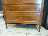 a wooden chest of drawers on a tiled floor