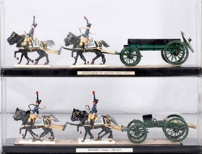 four miniature figurines of soldiers riding on horses and carts