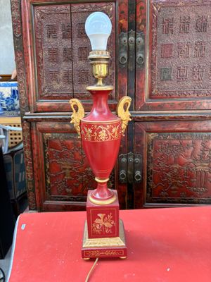 une table rouge sur laquelle est posée une lampe