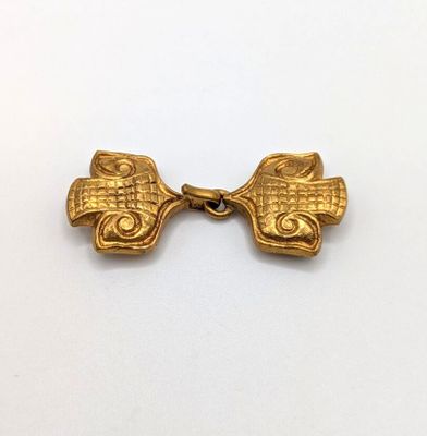 a close up of a gold plated metal object on a white surface