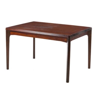 La table est en bois et présente une finition marron foncé.