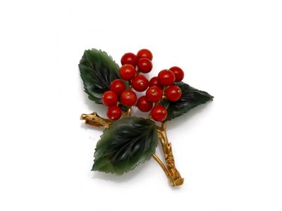 a close up of a brooch of berries on a white surface