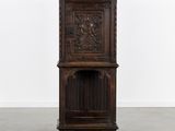 une vieille armoire en bois ornée de sculptures sur le dessus