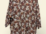 an image of a brown and white shirt with flowers on it